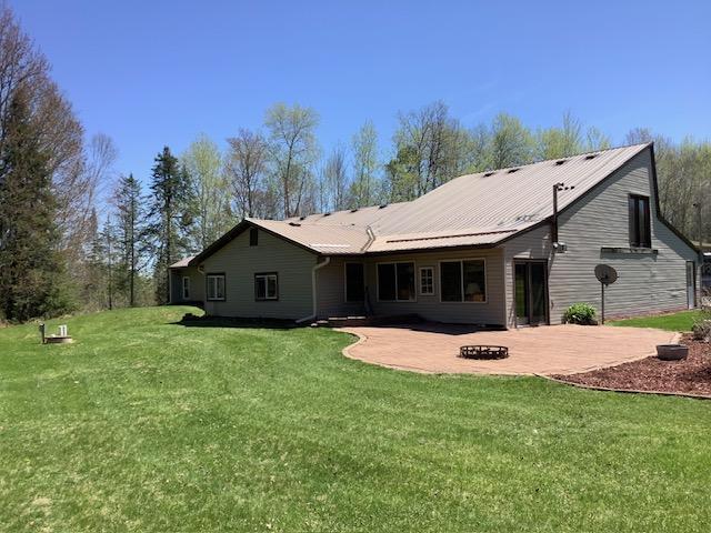 19323 Wendigo Park Rd, Harris Twp, MN 55744 - back of property with a patio, a yard, and a fire pit