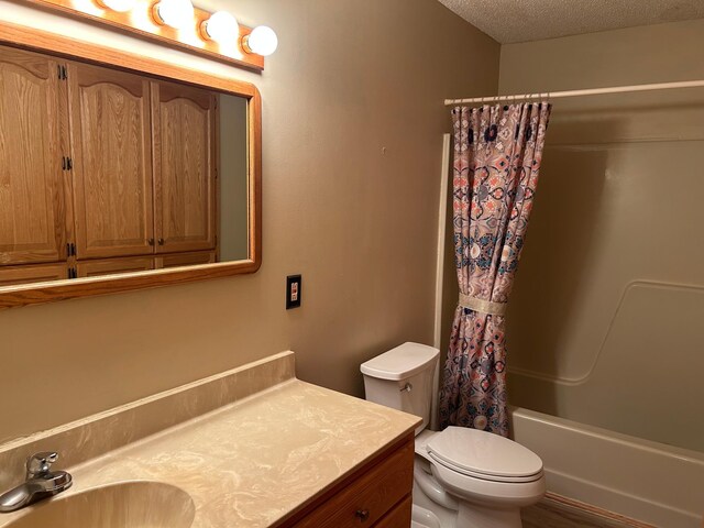 19323 Wendigo Park Rd, Harris Twp, MN 55744 - bathroom with toilet, shower / bath combo, vanity, and a textured ceiling