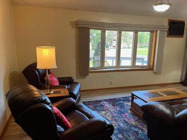 19323 Wendigo Park Rd, Harris Twp, MN 55744 - living area featuring baseboards, wood finished floors, and a wall unit AC