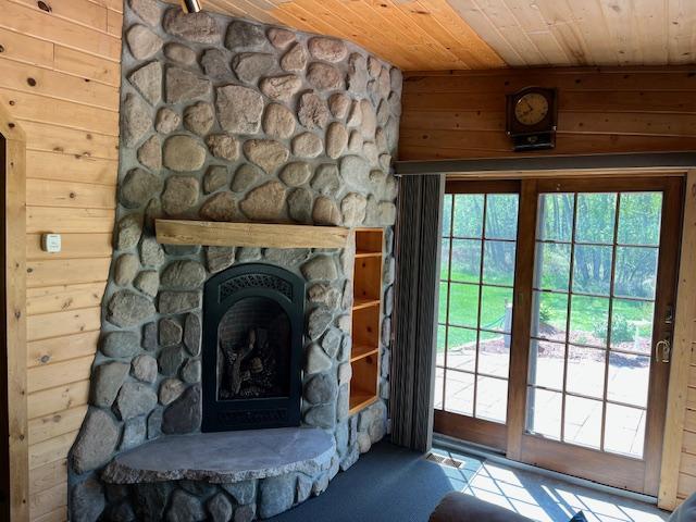 19323 Wendigo Park Rd, Harris Twp, MN 55744 - detailed view of wood ceiling, a stone fireplace, wood walls, and carpet flooring