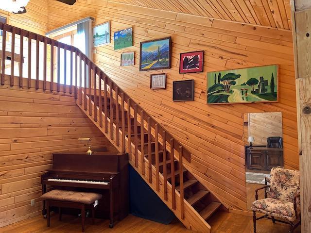 19323 Wendigo Park Rd, Harris Twp, MN 55744 - stairs with wooden walls, wood finished floors, and wooden ceiling
