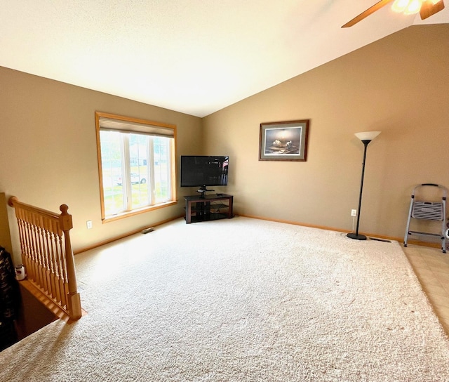 unfurnished living room featuring lofted ceiling, a ceiling fan, carpet, and baseboards