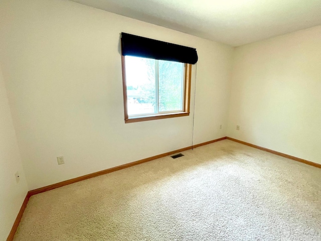 carpeted spare room with baseboards