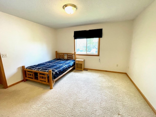carpeted bedroom with baseboards and a textured ceiling
