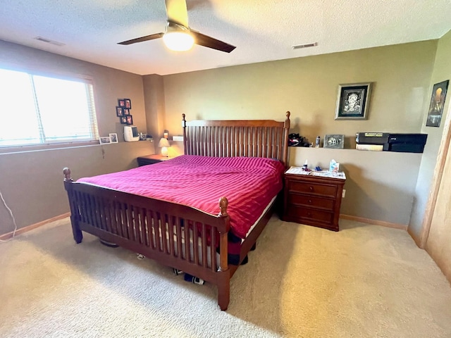 carpeted bedroom featuring a textured ceiling, a ceiling fan, and baseboards