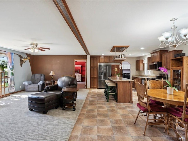 living area featuring a ceiling fan, a chandelier, recessed lighting, and light stone finish flooring