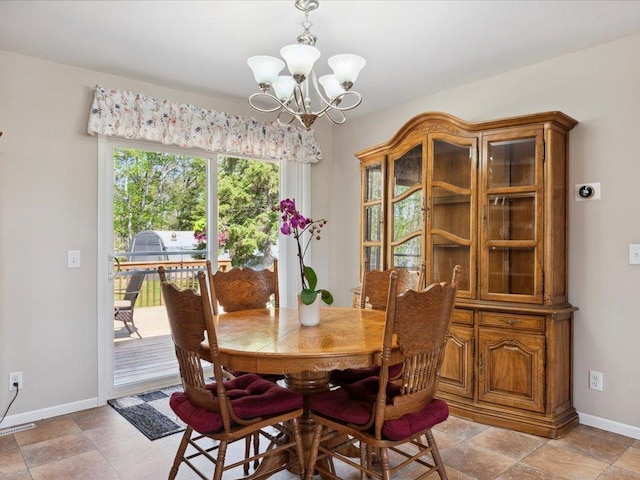 dining space featuring a chandelier and baseboards