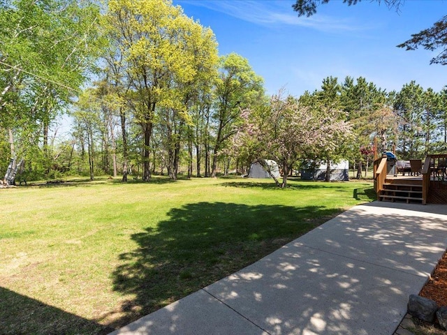 view of grassy yard with a wooden deck
