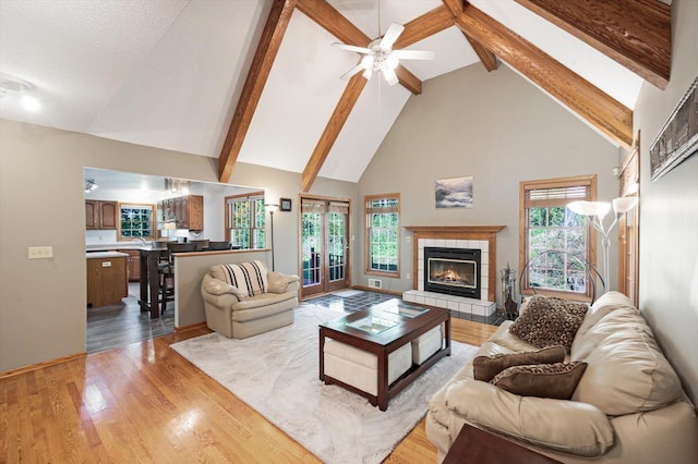 771 County Road B2 E, Little Canada, MN 55117 - living room with high vaulted ceiling, a tiled fireplace, a ceiling fan, light wood-style floors, and beam ceiling