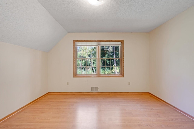 771 County Road B2 E, Little Canada, MN 55117 - additional living space featuring light wood finished floors, a textured ceiling, vaulted ceiling, and baseboards