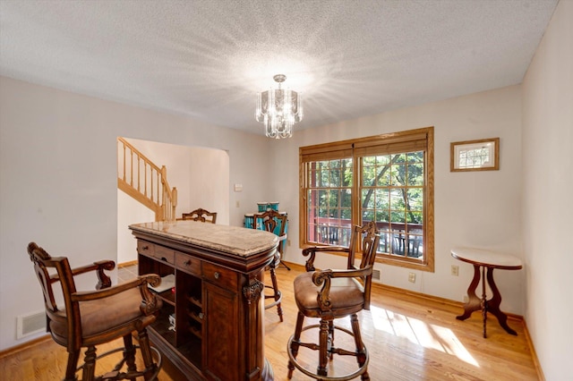771 County Road B2 E, Little Canada, MN 55117 - dining room with light wood-style flooring, a chandelier, stairway, and a textured ceiling