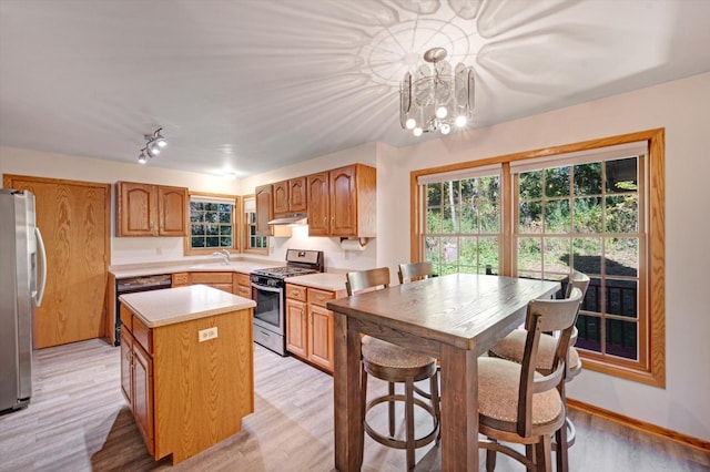 771 County Road B2 E, Little Canada, MN 55117 - kitchen featuring stainless steel appliances, under cabinet range hood, light countertops, a center island, and light wood finished floors