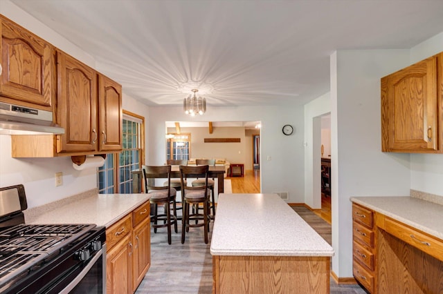 771 County Road B2 E, Little Canada, MN 55117 - kitchen with gas range, under cabinet range hood, light countertops, and light wood finished floors
