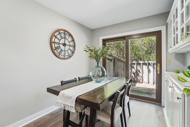 dining room with light wood finished floors and baseboards