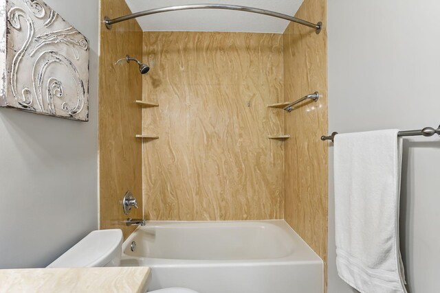 bathroom featuring toilet, shower / bathtub combination, and vanity