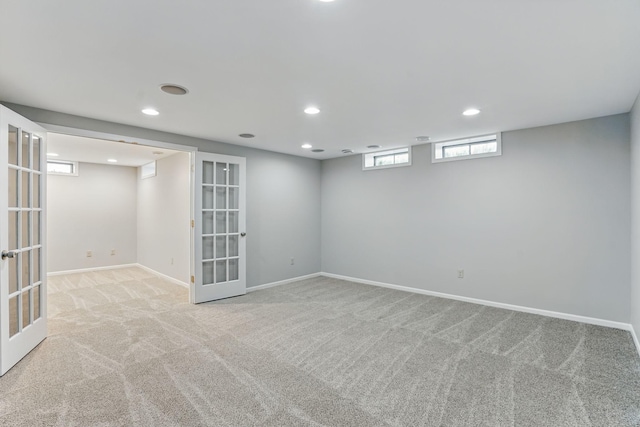 below grade area featuring french doors, carpet floors, recessed lighting, and baseboards