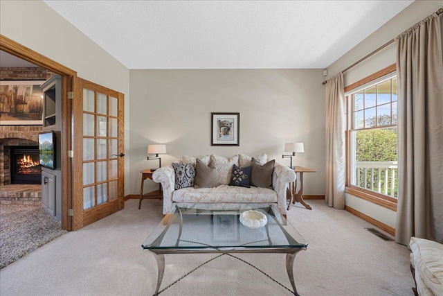 carpeted living room featuring baseboards and a fireplace