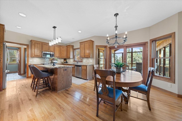 dining space featuring a chandelier, light wood-style flooring, baseboards, and recessed lighting
