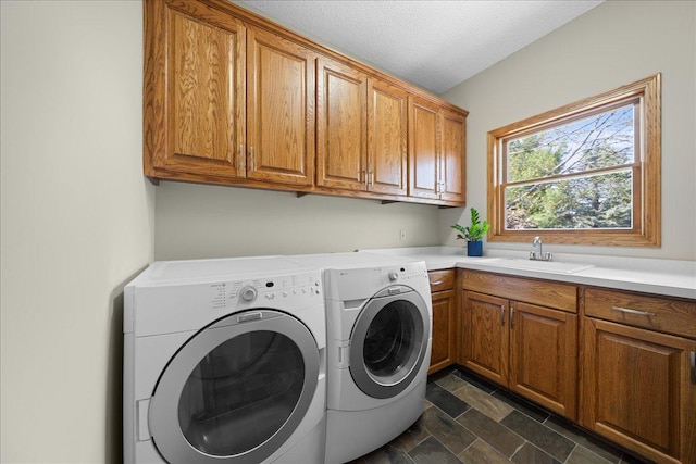 laundry area featuring cabinet space, washer and clothes dryer, and dark stone finish flooring