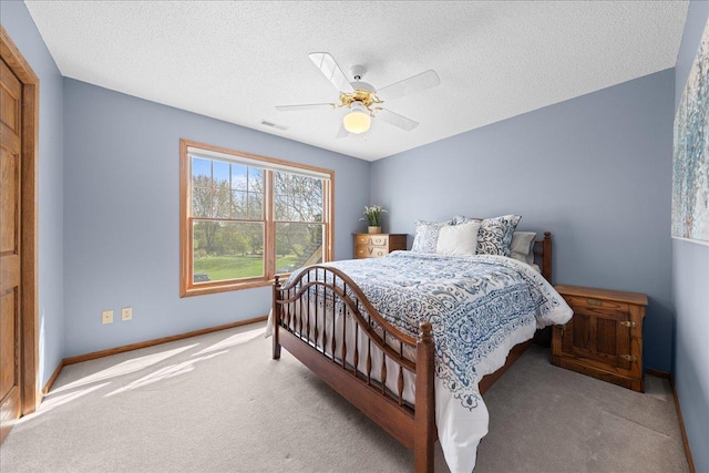 carpeted bedroom with baseboards, a ceiling fan, and a textured ceiling