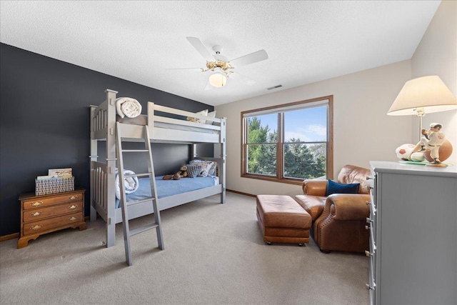 bedroom with light carpet, ceiling fan, a textured ceiling, and baseboards