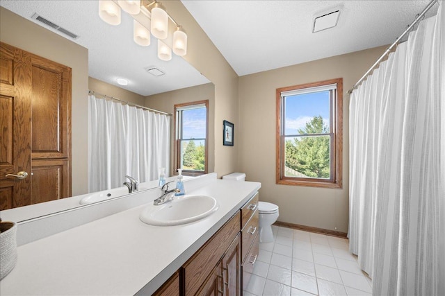 bathroom featuring baseboards, toilet, vanity, and tile patterned floors