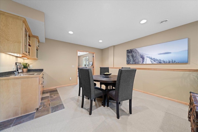 carpeted dining space featuring a sink, baseboards, and recessed lighting