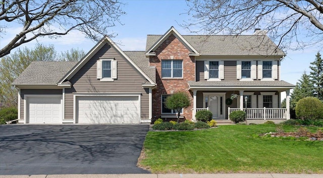 view of front of house with driveway, a chimney, a porch, a front lawn, and brick siding