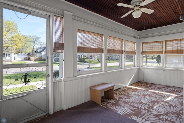 unfurnished sunroom featuring a ceiling fan