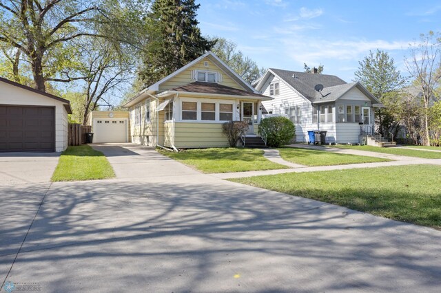 view of front of house with an outbuilding, concrete driveway, and a front yard
