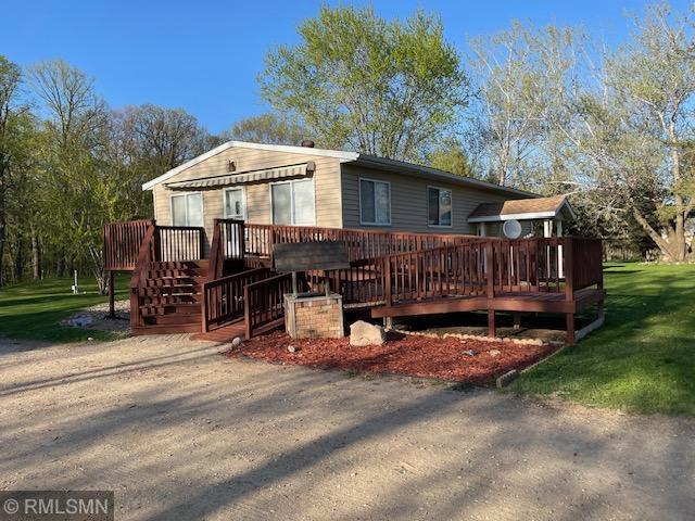 back of property with a deck and a yard