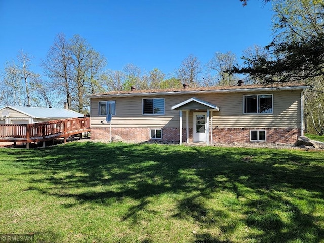 rear view of house with a wooden deck and a yard