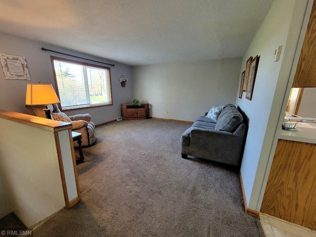living area featuring carpet floors, baseboards, and a textured ceiling