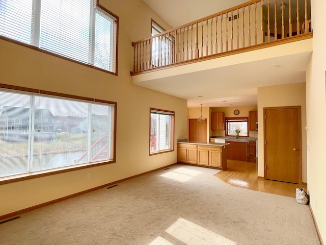 1986 Mathias Rd, Shakopee, MN 55379 - unfurnished living room with light colored carpet, baseboards, and a towering ceiling