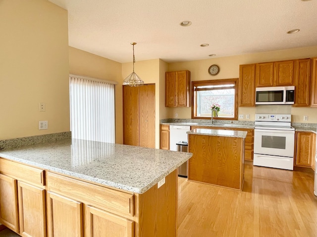 1986 Mathias Rd, Shakopee, MN 55379 - kitchen with white appliances, a sink, a peninsula, light wood-style floors, and light stone counters