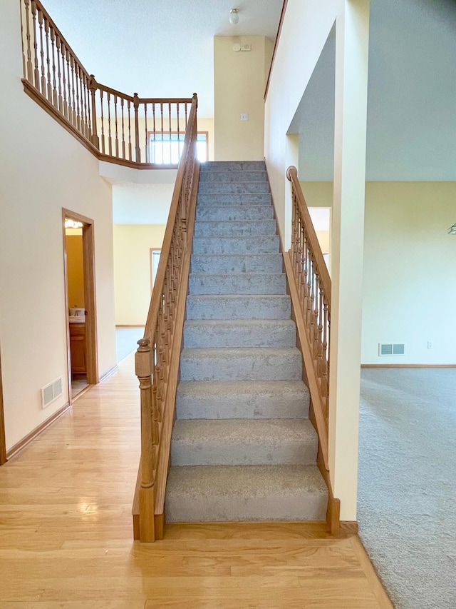 1986 Mathias Rd, Shakopee, MN 55379 - staircase with a high ceiling, wood finished floors, and baseboards