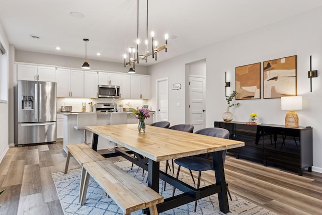 6813 5th St N, Brooklyn Center, MN 55430 - dining space featuring light wood-type flooring, recessed lighting, baseboards, and a chandelier