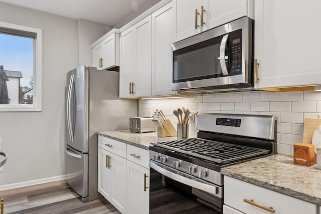 6813 5th St N, Brooklyn Center, MN 55430 - kitchen featuring appliances with stainless steel finishes, wood finished floors, baseboards, white cabinets, and tasteful backsplash