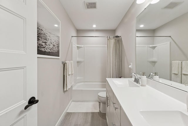 6813 5th St N, Brooklyn Center, MN 55430 - bathroom with wood finished floors, double vanity, toilet, baseboards, and shower / bath combo with shower curtain