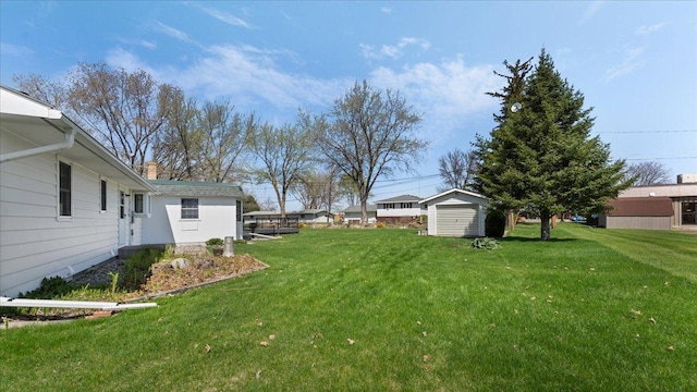 view of grassy yard featuring a shed and an outdoor structure