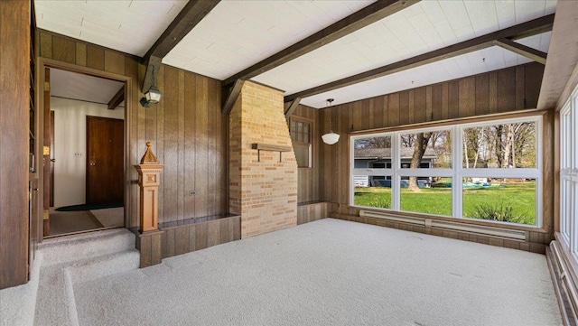 carpeted empty room with wood walls and beamed ceiling