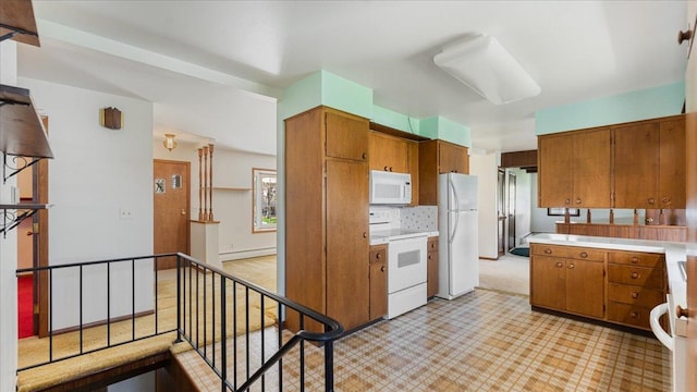 kitchen featuring white appliances, brown cabinets, baseboard heating, and light countertops