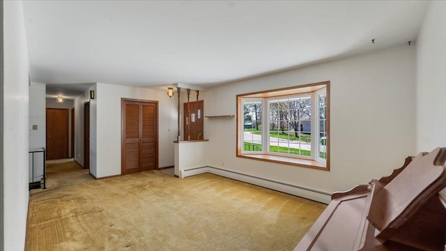 spare room featuring carpet flooring, baseboard heating, and baseboards