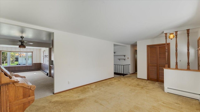 carpeted living room featuring baseboard heating, a ceiling fan, and baseboards