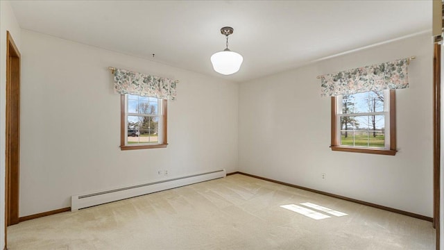 unfurnished room featuring baseboard heating, light colored carpet, and baseboards