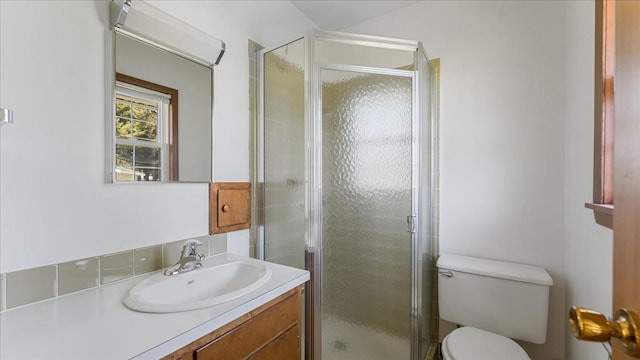bathroom featuring a stall shower, vanity, and toilet