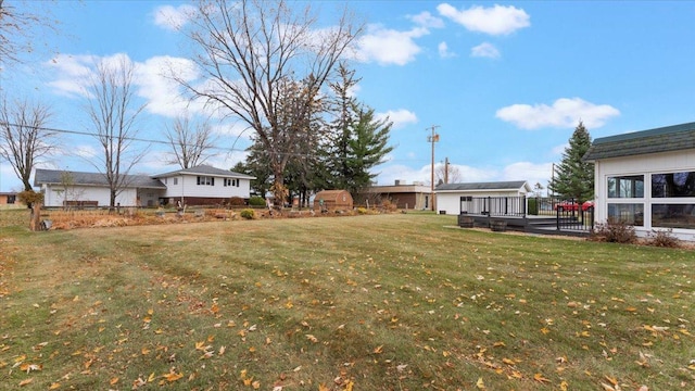 view of green lawn with a wooden deck