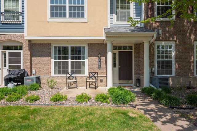 17208 72nd Ave N, Maple Grove, MN 55311 - doorway to property featuring central AC, brick siding, and stucco siding
