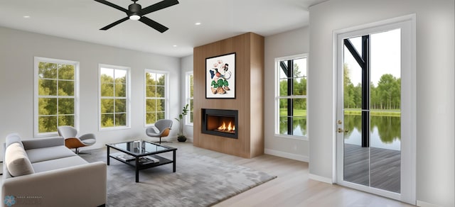 living area with ceiling fan, light wood-type flooring, a fireplace, recessed lighting, and baseboards