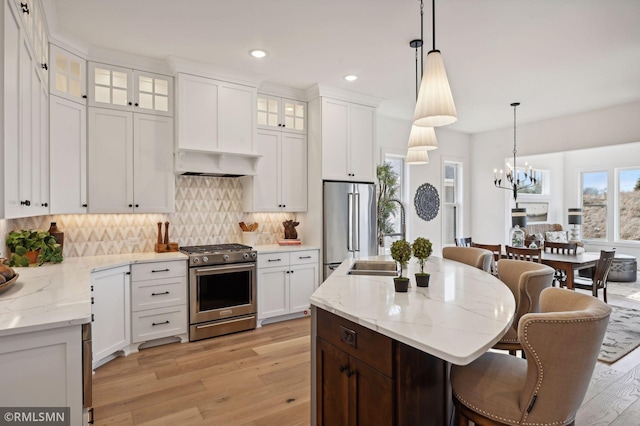 13708 Park Haven Trl, Prior Lake, MN 55372 - kitchen with appliances with stainless steel finishes, light wood-type flooring, a chandelier, a kitchen breakfast bar, and white cabinets
